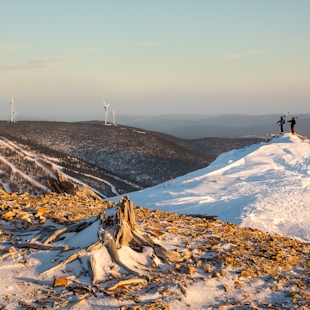Two skiers looking at wind turbines in the Chic-Choc Mountains