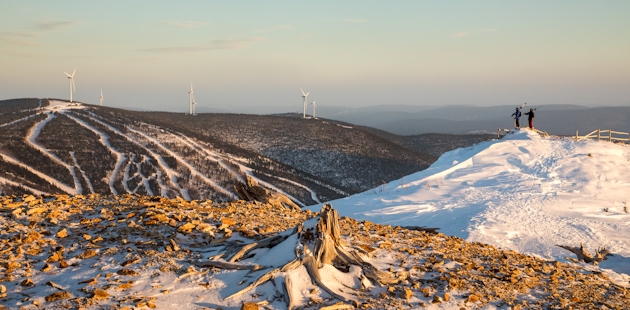 Two skiers looking at wind turbines in the Chic-Choc Mountains