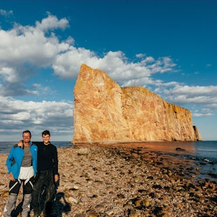 Motocyclists posing in front of Percé Rock