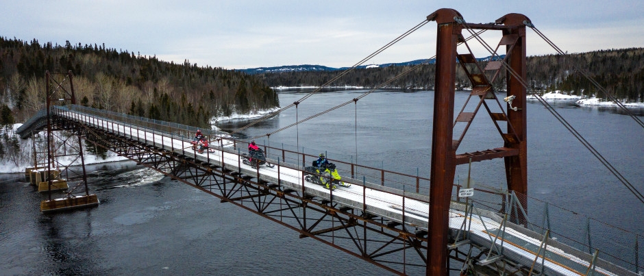 La passerelle est située sur le tracé du sentier Trans-Québec 3 - Crédit photo : JB Film Production/Tourisme Côte-Nord À voir en motoneige : la passerelle de la rivière Manicouagan