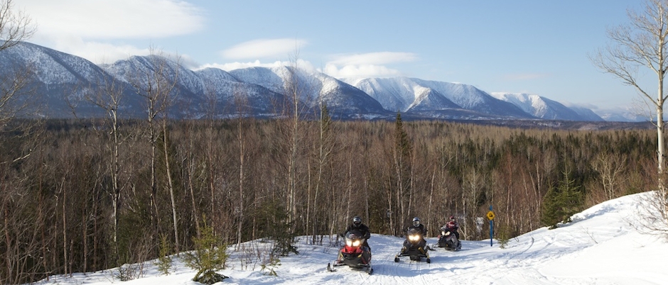 Snowmobiling with the Chic-Chocs in the background - Photo Credit: Studio du Ruisseau Snowmobile Trip in the Gaspé Peninsula: 7 Must-See Sectors!