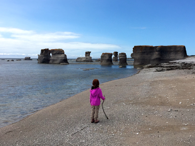 Petite fille qui regarde les monolithes de Mingan